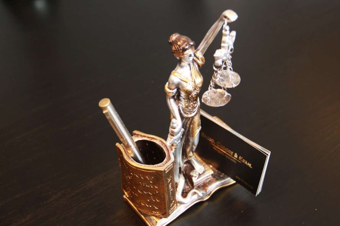Detalhe da mesa com estátua da Justiça